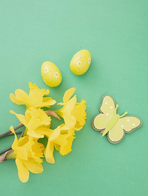 Ostereier gelbe Narzissen Blumen Bündel Frühlingssaison Dekoration auf grün