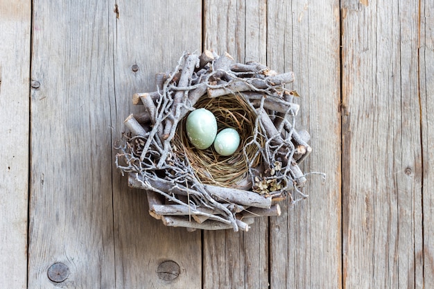 Ostereier im Nest auf grauer hölzerner Tischoberansicht