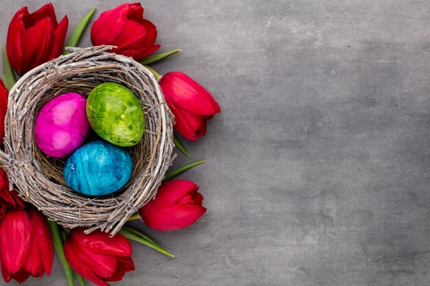 Ostereier im Nest. Frühlingsblumen Tulpen.Frühlingsgrußkarte.