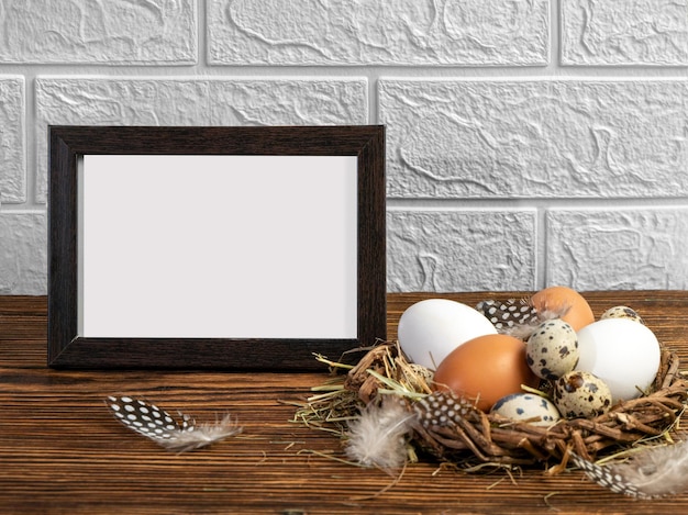 Ostereier in einem Nest auf einem hölzernen Hintergrund und einem Rahmen mit einem Platz für Text Ostergrußkarte