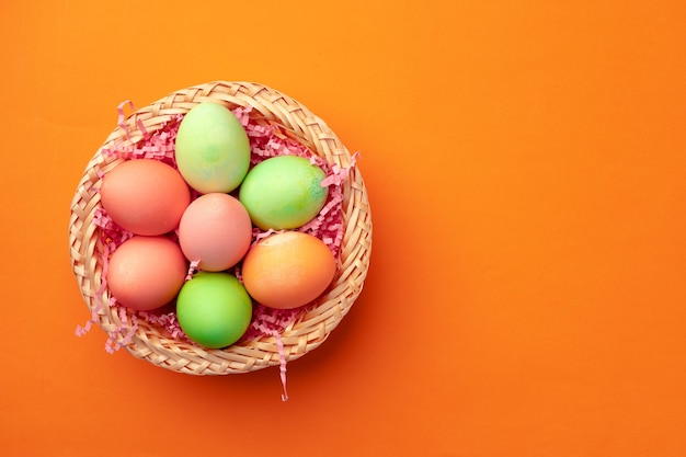 Ostereier in einem Nest auf Orange schließen