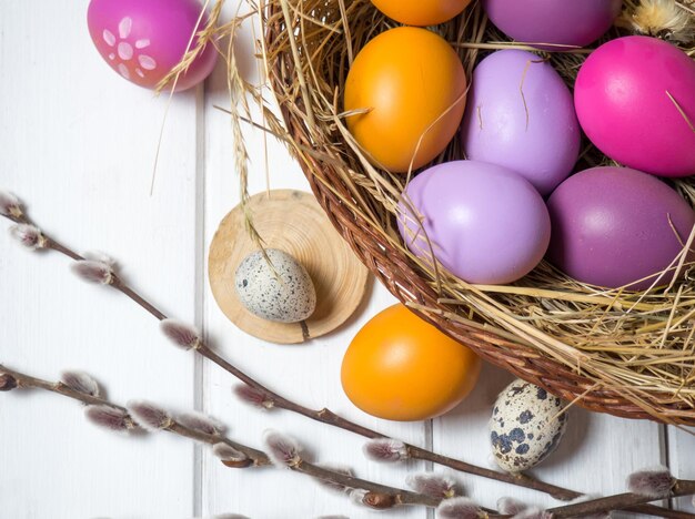 Ostereier in einem Nest auf weißem Holzhintergrund Das minimale Konzept von Ostern Draufsicht Eine Osterkarte mit einer Kopie des Platzes für den Text