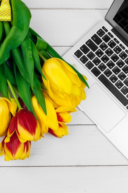 Ostereier, Laptop und Strauß Tulpen