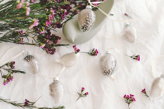 Ostereier mit Blumen auf weißem Leinenstoff Frühlings- und Osterkonzept