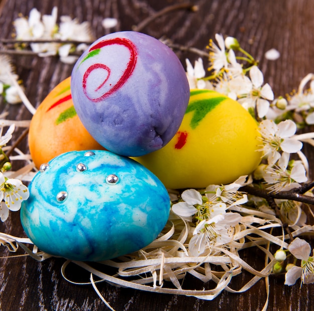 Ostereier mit Frühlingsblume auf Holztisch