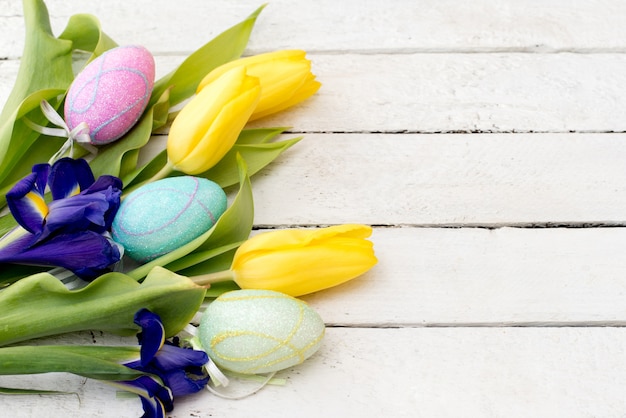 Ostereier und Blumen auf Holzbrettern mit einem Kopierraum