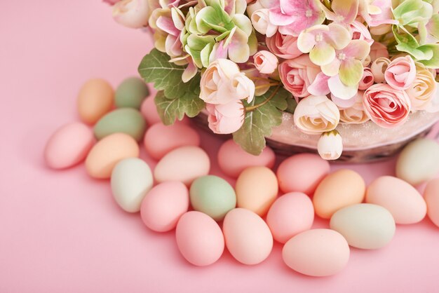 Ostereier und Blumen auf rosa Hintergrund. Osterdekoration mit Eiern.