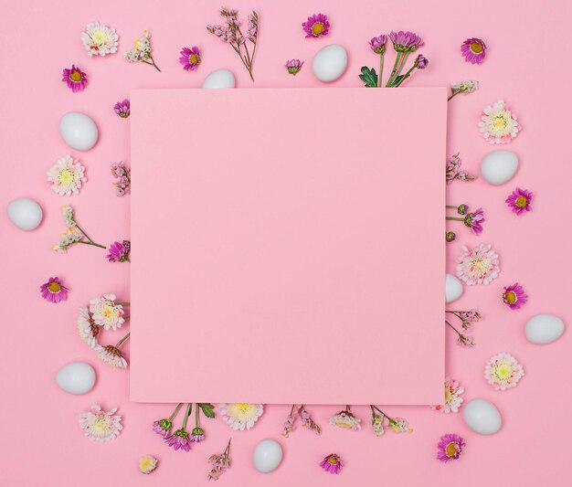 Ostereier und Blumen um rosa Papier kopieren