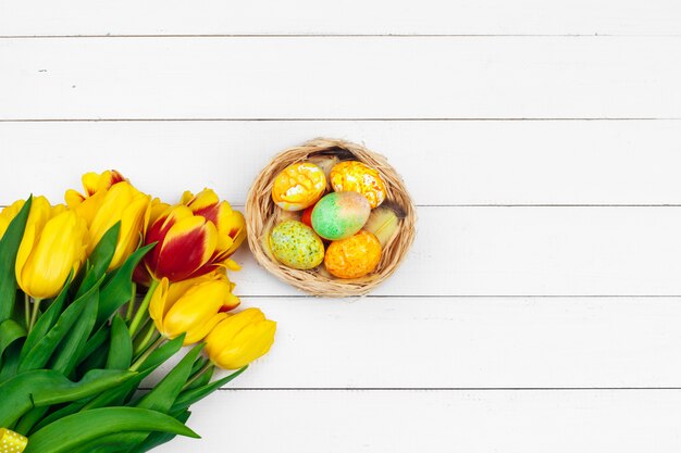 Ostereier und Tulpen auf Holzbohlen