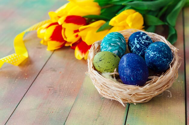 Ostereier und Tulpen auf Holzbohlen