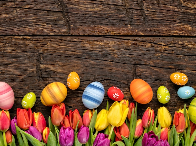 Ostereier und Tulpen auf Holzbohlen