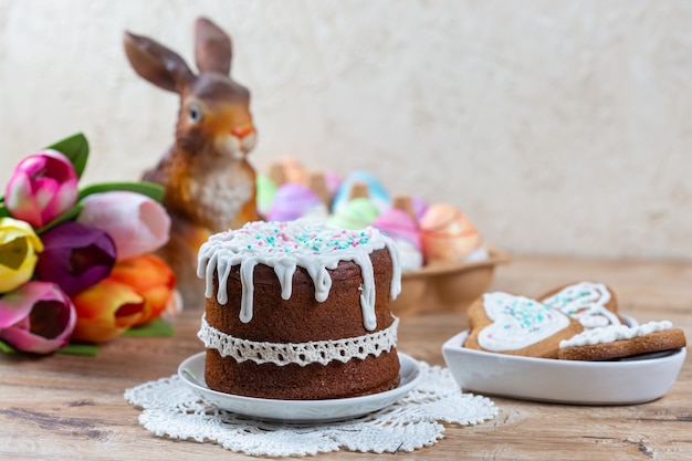 Osterfeierkonzept mit Kuchen, Keksen, Kaninchen und Ostereiern