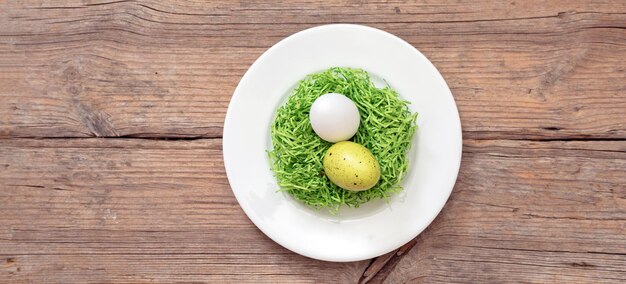 Osterfeiertags-Tischfeier Ei-Nest-Dekoration in einer weißen Schale auf einem Holztisch über dem Kopf