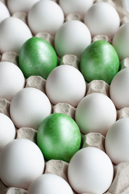 Osterferieneier in einem hellen Fach weiß und grün gefärbte Hühnereier Konzeptfoto