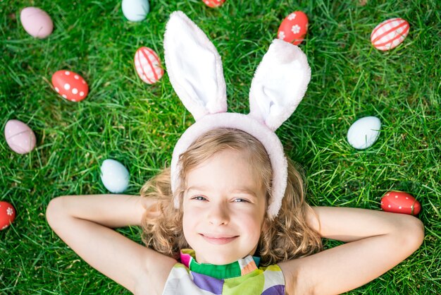 Osterhase. Kind, das Spaß im Freien hat. Kind, das mit Eiern auf grünem Gras spielt. Frühlingsferien-Konzept