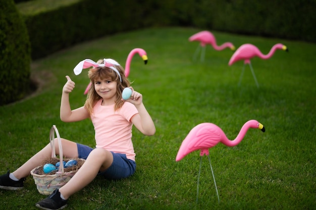 Osterhasenjunge mit niedlichem Gesicht Kinder jagen Ostereier Ostereiersuche