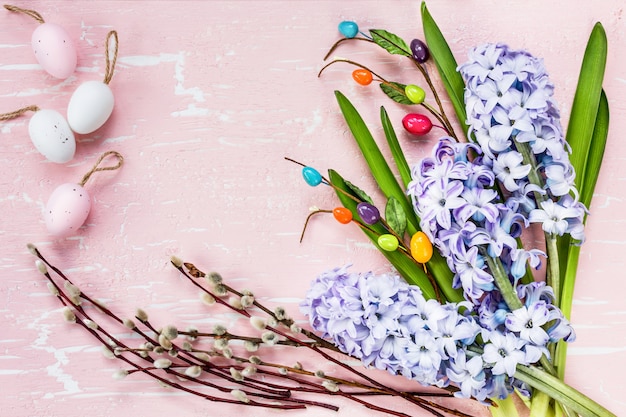 Osterhintergrund mit Blumen und dekorativen Eiern. Draufsicht, Kopierraum