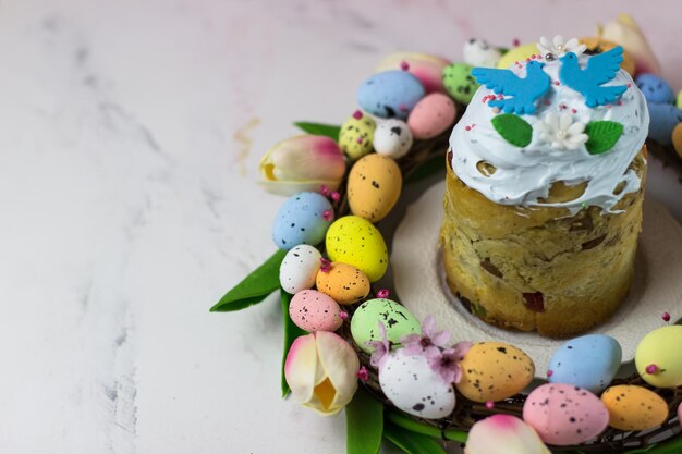 Osterkarte Kulich mit Zuckerfudge in einem Kranz aus Tulpen und Eiern Marshmallow Fudge mit Dekoration Platz für Text