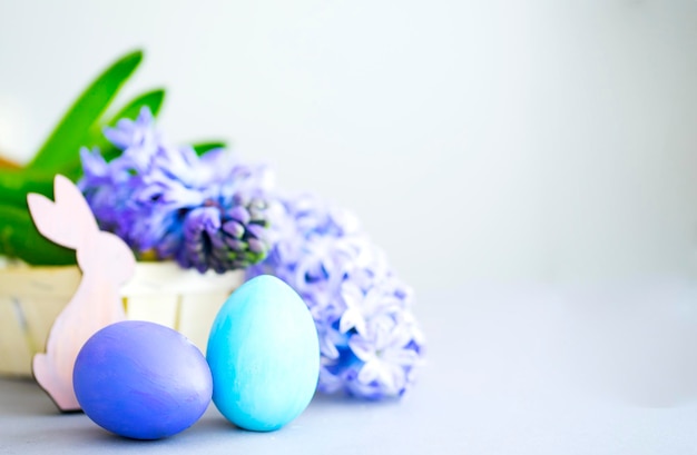 Osterkomposition in Blau- und Lilatönen Bemalte Eier und Hyazinthenblumen