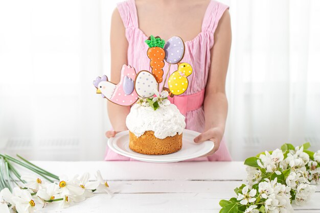 Osterkomposition mit einem festlichen Kuchen, verziert mit Lebkuchen auf Stöcken.