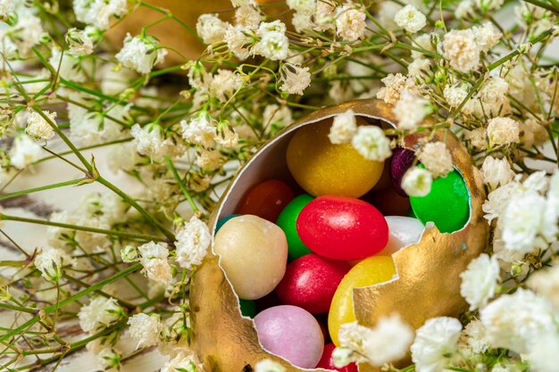 Osterkonzept. Eier und farbige Süßigkeiten auf dem Tisch schließen