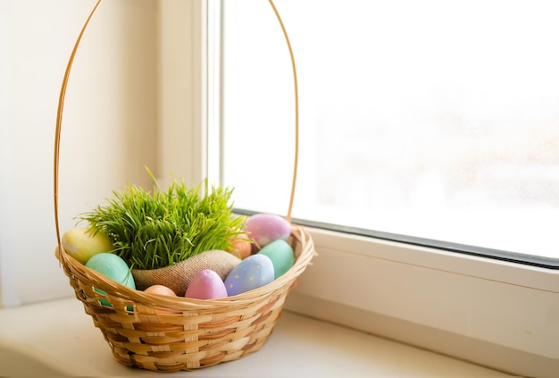 Osterkorb mit Hasenohren auf der Fensterbank Hochwertiges Foto