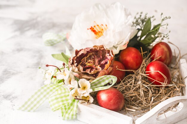 Osterkorb und rote Eier mit Blumen