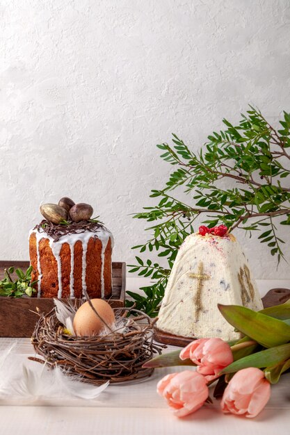 Osterkuchen, Blumen und Ei auf dem Tisch