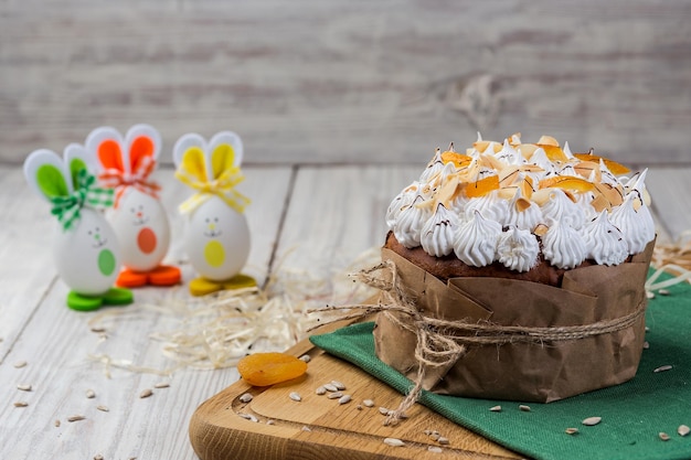 Osterkuchen Brot dekoriert mit Eiern Bonbons getrocknete Aprikosen und Sonnenblumenkerne auf Holzhintergrund Urlaubskonzept