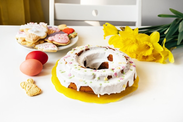 Osterkuchen Eier Blumen Narziss-Kekse auf weißem Tischgrund Osterferien