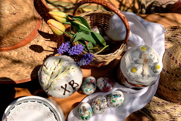 Osterkuchen Eier gelbe Tulpen und violette Blumen in einem Korb am Ostertag flach gelegt