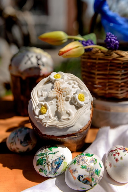 Osterkuchen Eier und gelbe Tulpen und violette Blumen in einem Korb am Ostertag