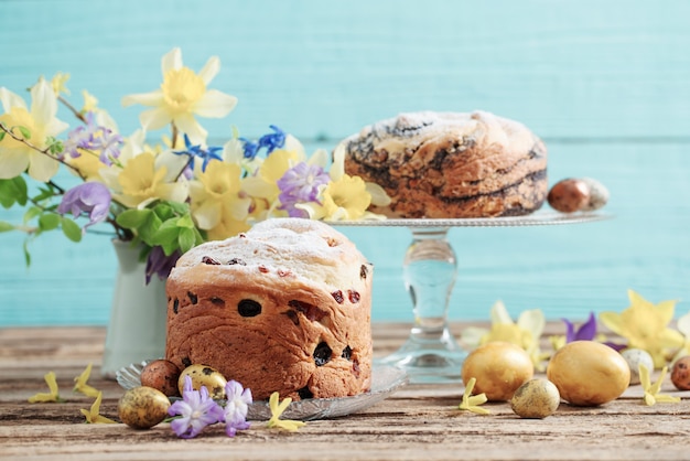 Osterkuchen und Eier auf blauem hölzernem Hintergrund