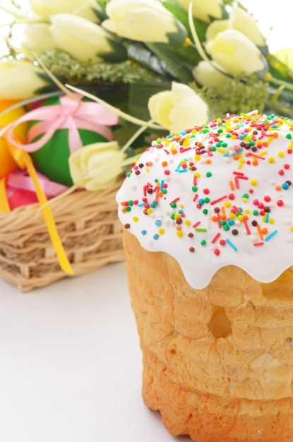 Osterkuchen und Korb mit bemalten Eiern auf Blumenhintergrund