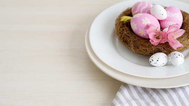 Ostermittagessen Feiertagstisch festliche Catering-Einladungskarte rosa weiße Farbe bemalte Eier mit