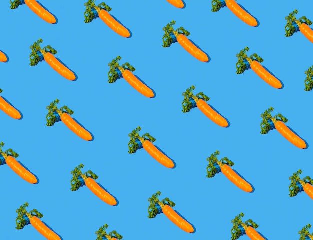 Ostermuster mit Karotten auf blauem Hintergrund Kreatives minimales Lebensmittelkonzept