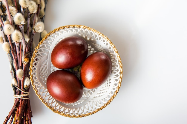 Ostern bemalte braune Eier und Weiden isoliert auf weißem Hintergrund. Ostertag.