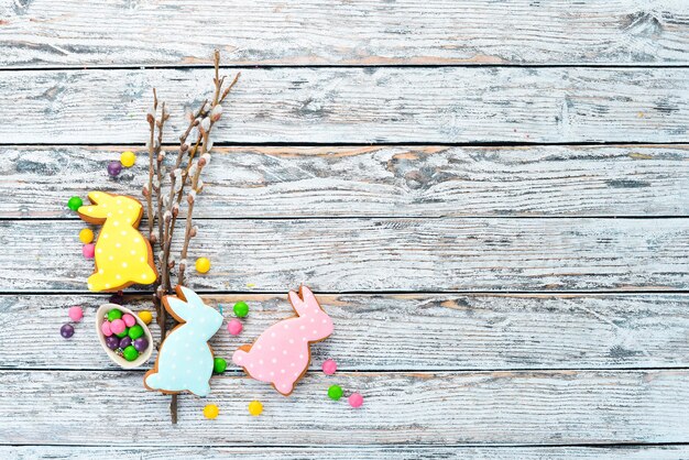 Ostern bunte Kuchen, dekorative Eier und Süßigkeiten. Grußkarte auf weißem Hintergrund aus Holz. Ansicht von oben. freier Kopierplatz.