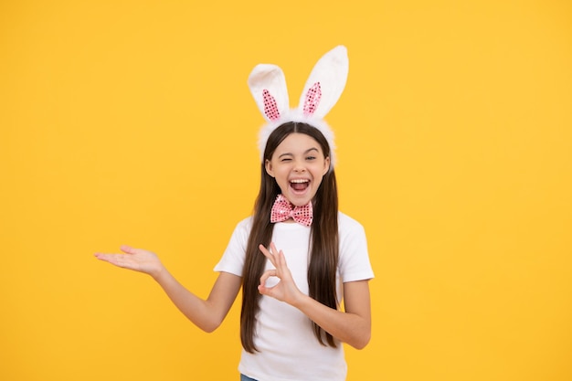 Ostern-Einkaufsverkauf, der nur Spaß hat, bereit für die Party, glückliche Kindheit, fröhliches Kind, das Produkt präsentiert, fröhlicher Osterurlaub, lustiges Kind in Hasenohren, Teenager-Mädchen in Fliege, Hasenjagd