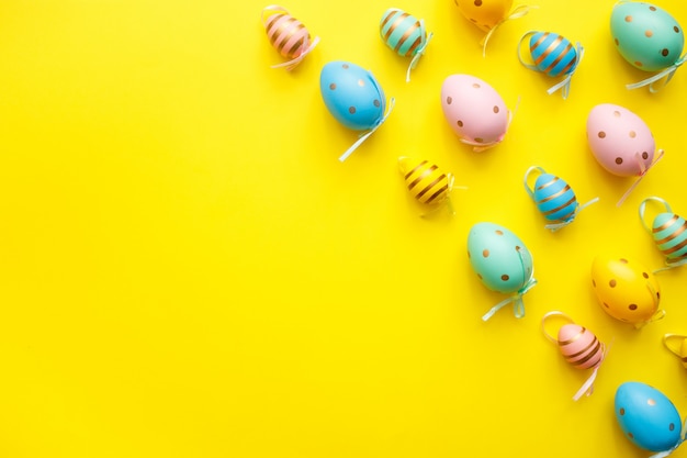 Foto ostern farbige eier auf gelbem hintergrund. minimales konzept der frohen ostergrußkarte. draufsicht, flach liegen