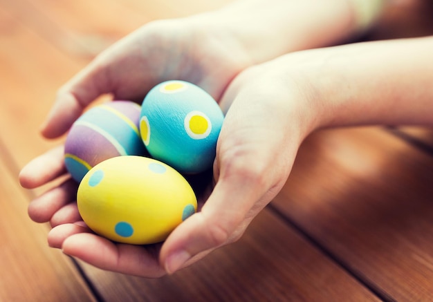 Ostern, Feiertage, Tradition und Menschenkonzept - Nahaufnahme von weiblichen Händen, die farbige Ostereier halten