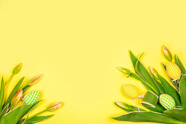 Ostern handgemachte Eier mit weißen zarten Tulpen auf gelbem Hintergrund Ostern dekorative ElementeHintergrund für die Grußkarte für OsternFrühling dekorative Elemente und BlumenFrühlingstreffen