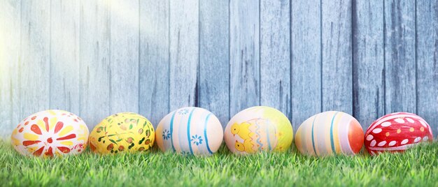 Ostern-Hintergrund mit bunten Ostereiern auf hölzernem Hintergrund