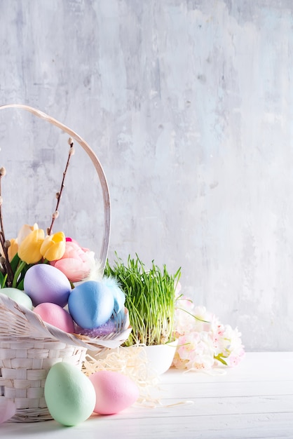 Ostern-Korb füllte mit bunten handgemalten Ostereiern über einem hellen Hintergrund