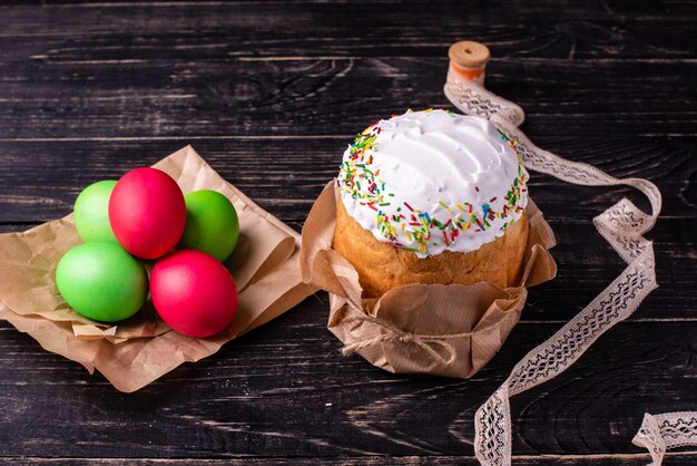 Ostern-Kuchen und bunte Eier auf einem dunklen Hintergrund