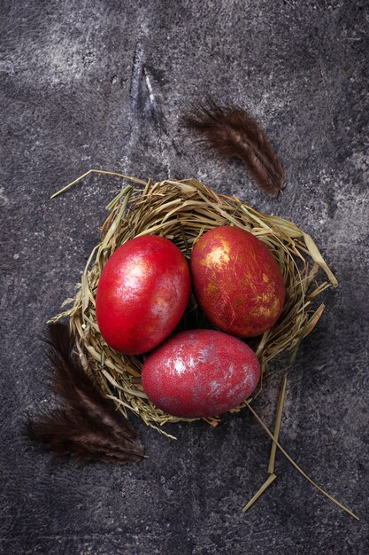 Ostern malte rote Eier auf Nest