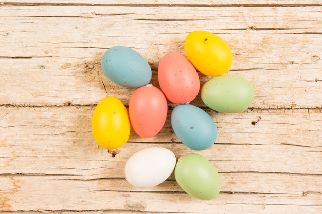 Ostern mit handgemachten bunten Eiern auf Holztisch.