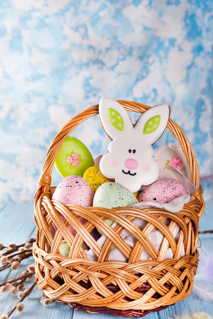 Ostern-Plätzchen, -Hasen und -eier in einem Korb auf hellblauem Hintergrund