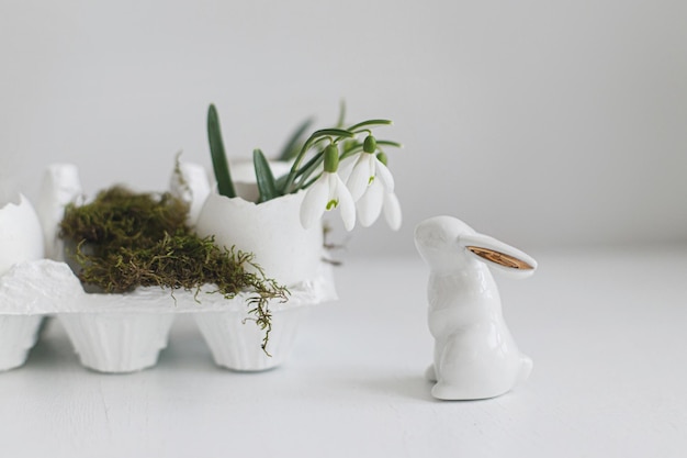 Ostern rustikales Stillleben Ostereierschalen mit blühenden Schneeglöckchen und süßer Häschenfigur