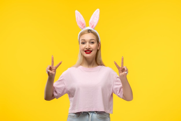 Ostern schönes süßes blondes Mädchen mit Hasenohren glücklich mit Friedenszeichen